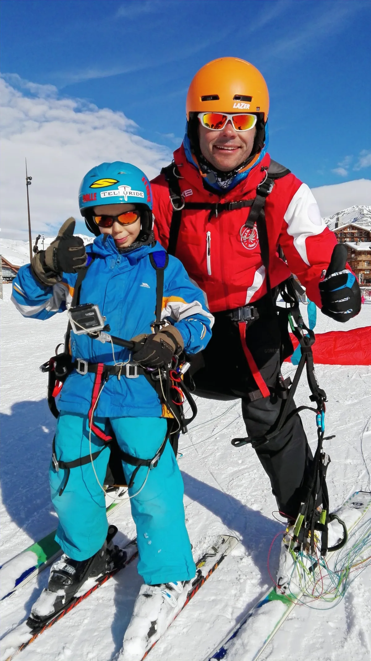 Enfant et moniteur pouce levé avant le décollage en parapente à Tignes