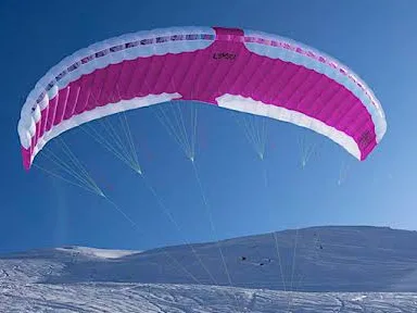Voile de speed riding rose et blanche gonflée dans le ciel bleu